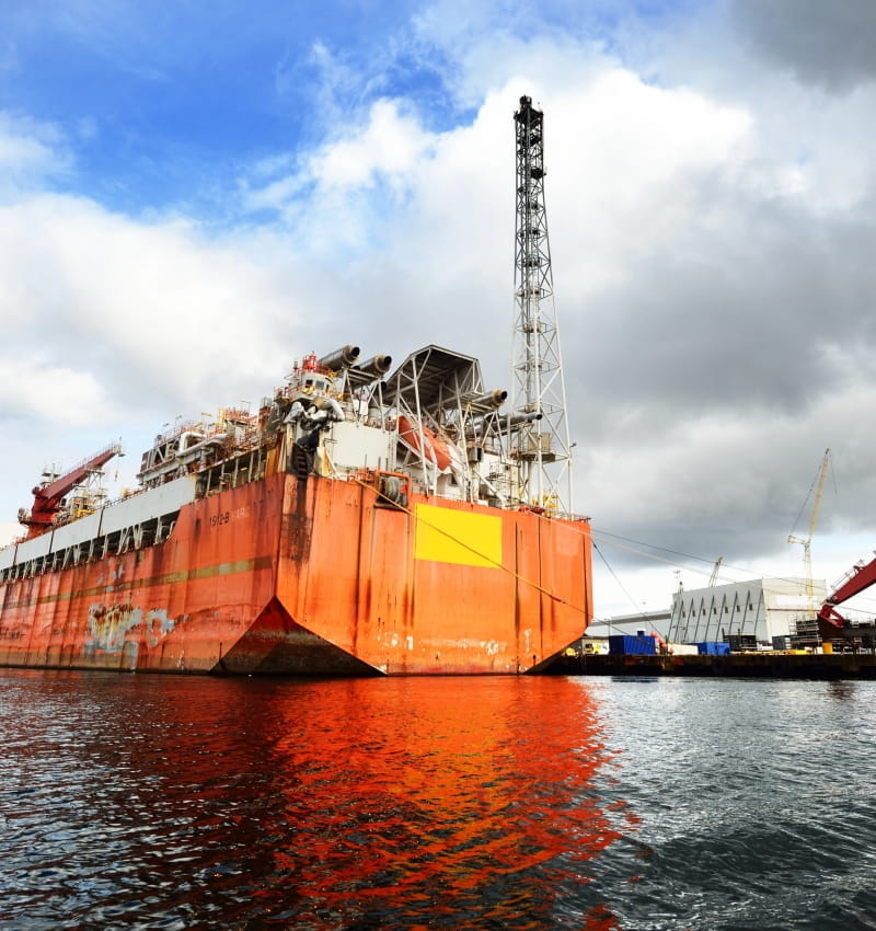 Large floating production, storage, and offloading (FPSO) vessel docked at an industrial port, representing offshore energy operations and the opportunity for carbon capture and emissions-reduction technologies to lower emissions from complex marine and industrial processes.